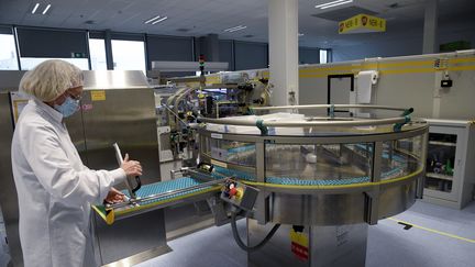 Une employée de la société britannique GSK sur une ligne de production d'adjuvants, le 3 décembre 2020, dans l'usine de Saint-Amand-les-Eaux (Nord). (FRANCOIS LO PRESTI / AFP)