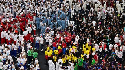 Les athlètes ont ensuite fait leur entrée au Stade de France, garnissant la piste violette. S'en est suivi un karaoké géant avec "Emmenez-moi" de Charles Aznavour, "Les Champs-Elysées" de Joe Dassin, "Freed from Desire" de Gala et "We Are The Champions" de Queen. (MIGUEL MEDINA / AFP)