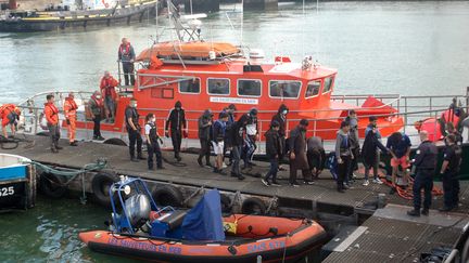 Des migrants venus pour la plupart d'Irak, d'Iran et d'Afghanistan débarquent d'un bateau de sauvetage de la SNSM après avoir été securus dans la Manche, le 15 septembre 2021, à Calais (Pas-de-Calais).&nbsp; (BERNARD BARRON / AFP)