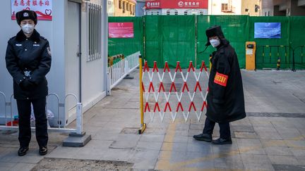 Le personnel de sécurité à l'extérieur d'un hôtel accueillant les équipes de médias, à l'intérieur de la bulle&nbsp;sanitaires des Jeux de&nbsp;Pékin, le 29 janvier 2022. (FABRICE COFFRINI / AFP)