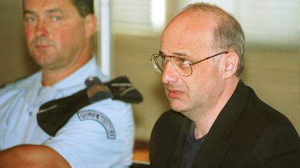 Jean-Claude Romand, dans le box des accusés pour l'ouverture de son procès, le 25 juin 1996 devant la Cour d'assises de l'Ain au palais de justice de Bourg-en-Bresse. (PHILIPPE DESMAZES / AFP)