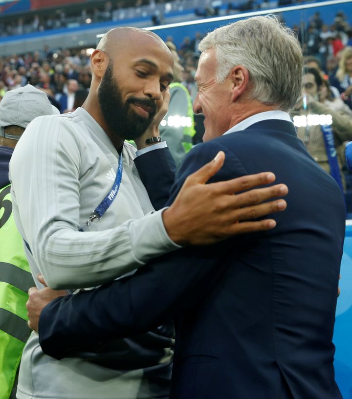 Didier Deschamps pose sa main sur une joue de Thierry Henry, le 10 juillet 2018, à Saint-Pétersbourg (Russie). (LEE SMITH / REUTERS)