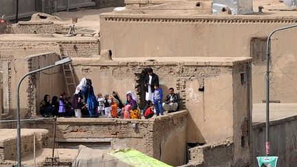 Une famille réunie sur un toit.
	  (AFP PHOTO / Aref KARIMI)