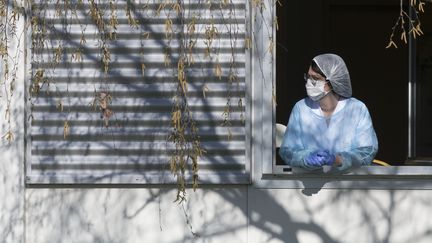 Une soignante à la fenêtre de l'hôpital Emile Muller, à Mulhouse, le 24 mars 2020. (SEBASTIEN BOZON / AFP)