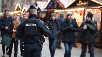 Un policier armé au marché de Noël de Strasbourg, le jour de sa réouverture, le 14 décembre 2018, après l'attentat qui avait fait cinq morts et 11 blessés (PATRICK HERTZOG / AFP)