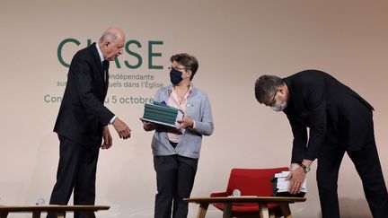 Jean-Marc Sauvé remet le rapport de la CIase à Véronique Margron, présidente de la Corref, et Eric de Moulins-Beaufort, président de la CEF, mardi 5 octobre 2021 à Paris. (THOMAS COEX VIA AFP)