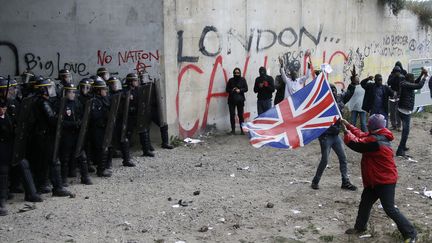 Des manifestants font face à des policiers, le 1er octobre 2016, à l'entrée de la "jungle" de Calais. (PASCAL ROSSIGNOL / REUTERS)