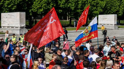 Des manifestants brandissent des drapeaux soviétiques à l'occasion des commémorations du 9 mai 1945 à Berlin, lundi 9 mai 2022. (CARSTEN KOALL / DPA)