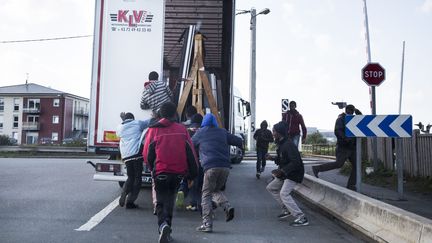 Des migrants profitent du fait qu'un camion &agrave; destination de l'Angleterre s'arr&ecirc;te &agrave; un stop pour tenter de s'introduire &agrave; l'int&eacute;rieur, le 9 octobre 2014, &agrave; Calais. (MAXPPP)