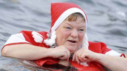 Une membre du club&nbsp;Berliner Seehunde (les phoques de Berlin) fait honneur &agrave; la tradition annuelle en se baignant dans le lac Orankesee, le 25 d&eacute;cembre 2011. (MAURIZIO GAMBARINI / DPA / AFP)