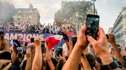 Des supporters acclament le bus des Bleus revenus victorieux&nbsp;de la Coupe du monde. L'équipe de France a défilé à Paris, le 16 juillet 2018. (SIMON GUILLEMIN / HANS LUCAS)