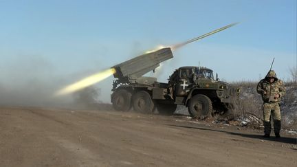 Un membre de l'armée ukrainienne regardant au loin alors qu'un lance-roquettes tire à la périphérie de Soledar, le 11 janvier 2023. (ARMAN SOLDIN / AFP)