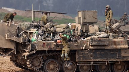 Des soldats israéliens sur un tank à la frontière entre Israël et la bande de Gaza, le 9 janvier 2024. (MENAHEM KAHANA / AFP)