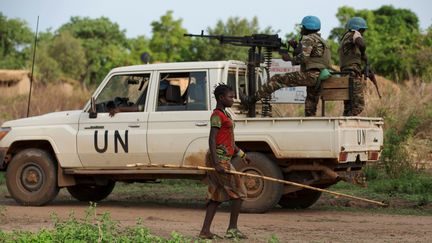 Une jeune fille passe devant une patrouille de casques bleus dans le village de Bambara en République centrafricaine le 25 avril 2017. (BAZ RATNER / X02483)