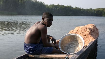 Dès leur plus jeune âge, les enfants sont sur l’eau. Ils apprennent à naviguer et à manier les filets, et à nager bien sûr. Mais l’activité est aussi à terre. Le fumage du poisson est indispensable pour la conservation. Il faut aller récupérer la sciure dans les scieries.
 (Steve Jordan/AFP)