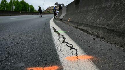 Une fissure sur la chaussée sur l'autoroute A13, dans les Hauts-de-Seine, le 19 avril 2024. (MIGUEL MEDINA / AFP)