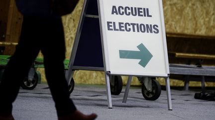 Un panneau indiquant l'emplacement du bureau de vote, le 15 mars 2020 lors du premier tour des élections municipales, peu avant l'instauration du confinement en France. (MATHIEU PATTIER / SIPA)