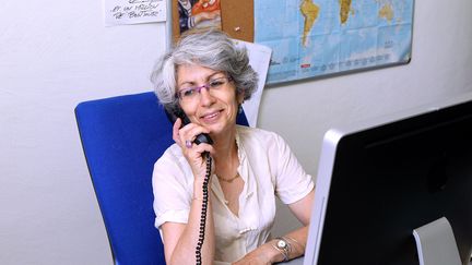 Une senior au téléphone à son bureau. (GUILLAUME BONNEFONT / MAXPPP)