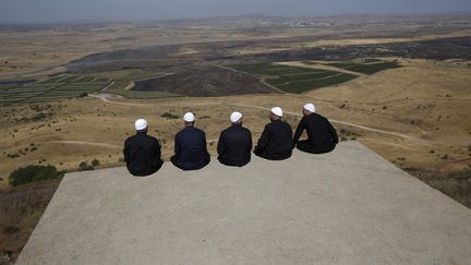 Des Druzes sur les hauteurs du Golan, annexées par les Israéliens, regardent la province de Quneitra, dans le sud-ouest de la Syrie, de l'autre côté de la frontière, le 7 juillet 2018. (JALAA MAREY / AFP)