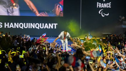 Alexis Hanquinquant, qui a conservé son titre paralympique au triathlon, célèbre sa médaille d'or avec le public du Club France, à la Porte de la Villette, à Paris, le 2 septembre 2024. (KELLERMAN YONATHAN / KMSP / AFP)