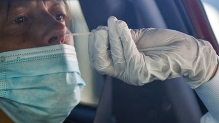 Un&nbsp;biologiste effectue un prélèvement pour le Covid-19 dans&nbsp;le parking de l'hôpital de Laval (Mayenne), le 9 juillet 2020. (JEAN-FRANCOIS MONIER / AFP)