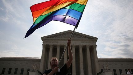 Un d&eacute;fenseur du mariage gay agite un drapeau arc-en-ciel devant la Cour supr&ecirc;me, &agrave; Washington, le 25 juin 2015. (MARK WILSON / GETTY IMAGES NORTH AMERICA / AFP)