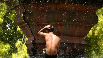 Un gar&ccedil;on indien se rafra&icirc;chit sous une fontaine, alors que la canicule s&eacute;vit &agrave; New Delhi (Inde), le 26 mai 2015. (CHANDAN KHANNA / AFP)