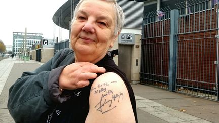 Nelly, 66 ans, le 6 décembre devant le Stade de France. Elle s'est fait tatouer une dédicace de Johnny Hallyday. (BENJAMIN ILLY / RADIO FRANCE)