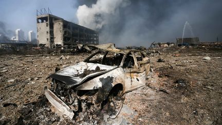 Une voiture souffl&eacute;e par la s&eacute;rie d'explosions qui a secou&eacute; la ville de Tianjin, en Chine, mercredi 12 ao&ucirc;t 2015. (AFP)