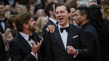 Le président du jury Ruben Östlund, doublement palmé, semble avoir glissé une petite blague à l'oreille de l'acteur Paul Dano, hilare. Les deux membres du jury montrent leur grande complicité en ce troisième jour de compétition. (DANIEL COLE/AP/SIPA / SIPA)