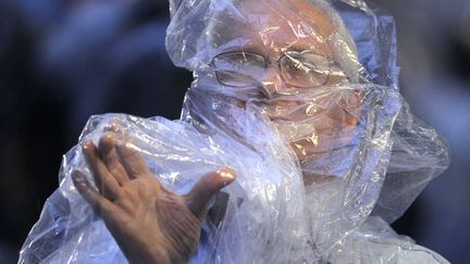 Un fid&egrave;le tente de se prot&eacute;ger de la pluie en attendant l'arriv&eacute;e du pape Fran&ccedil;ois &agrave; l'h&ocirc;pital de Saint Fran&ccedil;ois d'Assise &agrave; Rio de Janeiro (Br&eacute;sil), le 24 juillet 2013. (UESLEI MARCELINO / REUTERS)