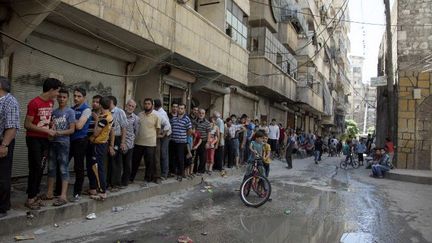 Dans Alep, assiégée par les forces de Bachar al-Assad, le pain se fait rare faute de farine et de mazout, et les habitants faisaient des heures de queue, le 12 juillet 2016, devant les rares boulangeries encore ouvertes dans les quartiers rebelles. (KARAM AL-MASRI/AFP)