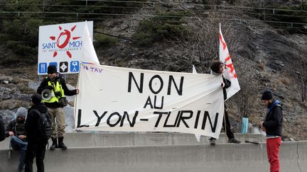 Des opposants au projet de ligne ferroviaire Lyon-Turin brandissent une banderole à Saint-Michel-de-Maurienne (Savoie). (JEAN-PIERRE CLATOT / AFP)