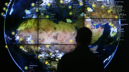 Un visiteur observe une carte m&eacute;t&eacute;o &agrave; l'a&eacute;roport de Kuala Lumpur, en Malaisie, le 18 mars 2014. (SAMUEL SAID / REUTERS)