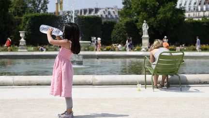 Une petite fille se désaltère, le 2 juillet 2015 à Paris. (MIGUEL MEDINA / AFP)