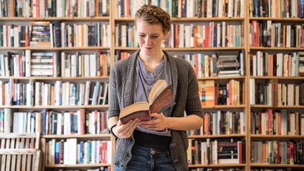 Jeune femme lisant dans une librairie
 (Luis Alvarez / Getty Images)