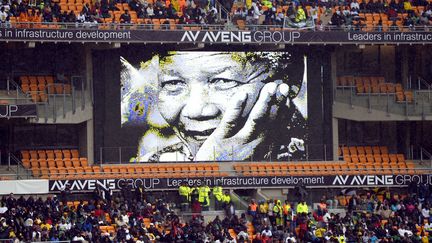 Nelson Mandela doit "sourire" depuis le ciel &agrave; la vue de la foule r&eacute;unie mardi pour la c&eacute;r&eacute;monie en son hommage dans un stade de Soweto, a d&eacute;clar&eacute; &agrave; la tribune le porte-parole de sa famille. (ODD ANDERSEN / AFP)