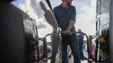 Un homme fait le plein d'essence dans sa voiture à une station-service dans l'Eure-et-Loir, le 12 octobre 2022. (QUENTIN REIX / MAXPPP)