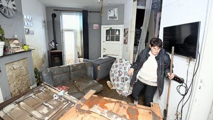 Une habitante examine les dégâts subis par une maison dans une zone détruite par les récentes inondations, à Trooz (Belgique), le 16 juillet 2021. (ERIC LALMAND / BELGA / AFP)