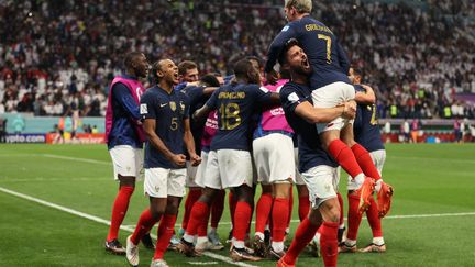 Passeur décisif, Antoine Griezmann saute dans les bras du buteur Olivier Giroud, samedi 10 décembre 2022, lors du quart de finale Angleterre-France. (ADRIAN DENNIS / AFP)