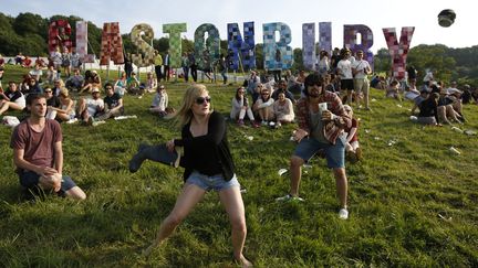 Une botte en caoutchouc, une canette de bi&egrave;re et les festivaliers de Glastonbury&nbsp;(Royaume-Uni) improvisent une partie de baseball en atendant les premiers concerts, le 27 juin 2013. (OLIVIA HARRIS / REUTERS)