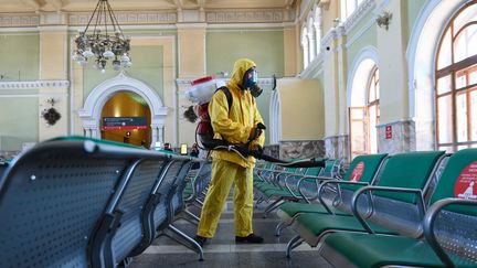 Un employé du&nbsp;ministère des Situations d'urgence désinfecte la gare de&nbsp;Rizhsky, à Moscou (Russie), le 17 juin 2021. (MAKSIM BLINOV / SPUTNIK / AFP)