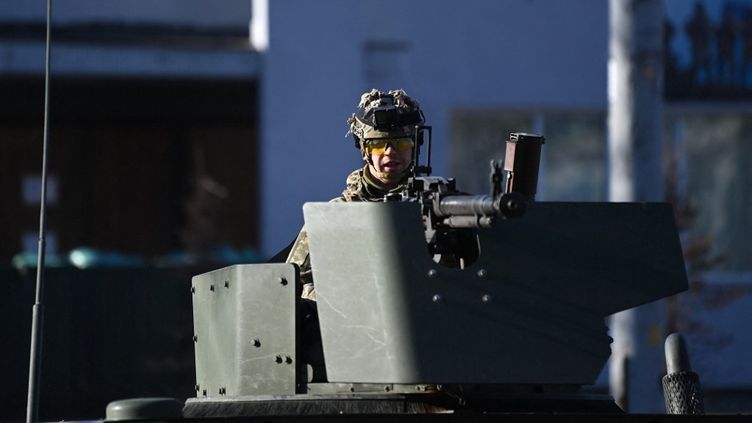 Un soldat ukrainien patrouille à bord d'un véhicule blindé dans les rues de Kiev, samedi 26 février 2022. (DANIEL LEAL / AFP)