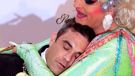 En mal de c&acirc;lins, Robbie Williams s'est laiss&eacute; aller sur une (fausse) poitrine fort imposante. On aimerait savoir &agrave; quoi ressemble maman Williams... (MALTE CHRISTIANS / DPA / AFP)