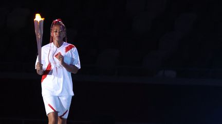 Naomi Osaka s'avance pour allumer la vasque olympique dans le stade olympique de Tokyo lors de la cérémonie d'ouverture, le 23 juillet.&nbsp; (TAKUMI HARADA / YOMIURI)