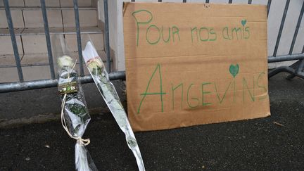 Des fleurs ont été déposées devant l'immeuble, ainsi qu'une pancarte "Pour nos amis angevins". (16 octobre 2016) (JEAN-FRANCOIS MONIER / AFP)