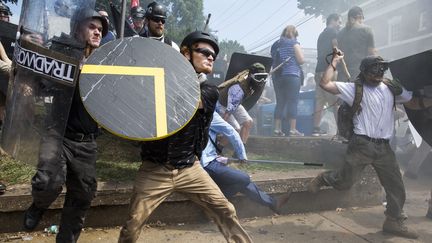 Des militants d'extreme droite armés de boucliers et de bâtons affrontent des contre-manifestants antiracistes, à Charlottesville (Virginie), le 12 août 2017. (SAMUEL CORUM / ANADOLU AGENCY / AFP)