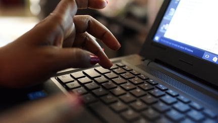 Une femme utilise un ordinateur. Photo d'illustration. (ISSOUF SANOGO / AFP)