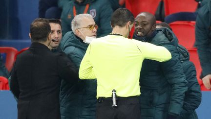 Pierre Achille Webo s'adresse à l'arbitre du match, le Roumain Ovidiu Hategan, le 8 décembre 2020 au Parc des Princes, à Paris. (CHARLES PLATIAU / REUTERS)