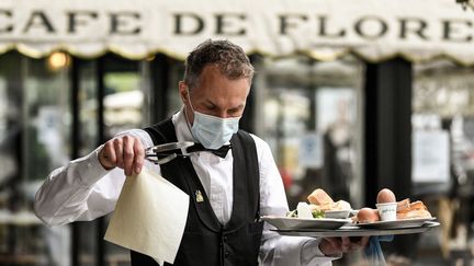 Un serveur travaille à la terrasse du Café de Flore, à Paris, le 19 mai 2021 (BERTRAND GUAY / AFP)